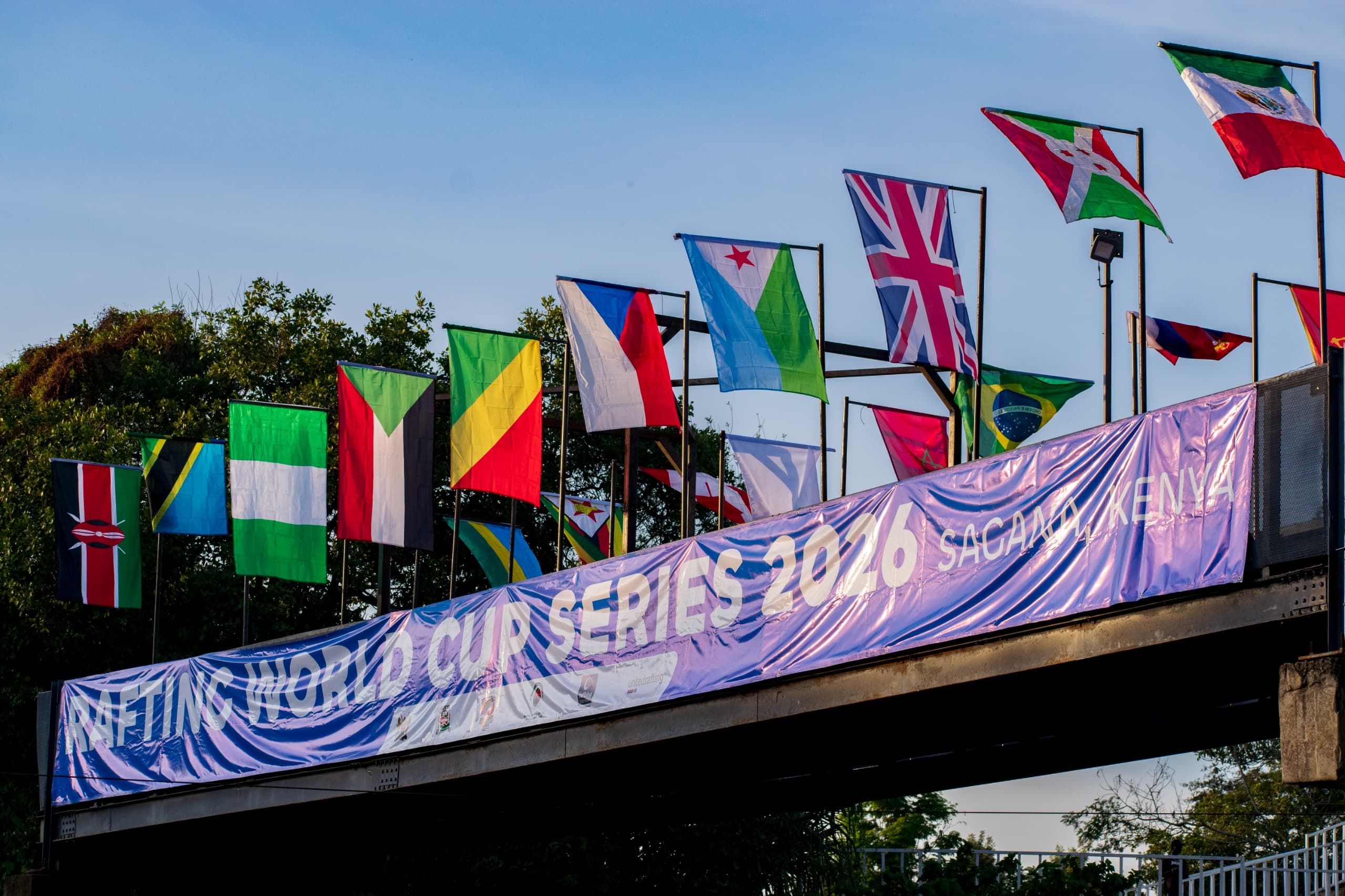 National flags flying above the Rafting World Cup Series 2026 banner in Sagana, Kenya